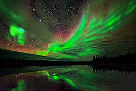 Aurora borealis over lake in Yellowknife, Canada.